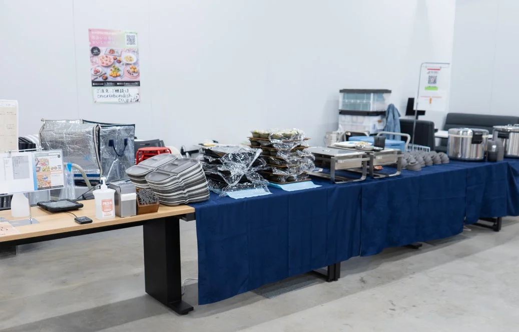イベント会場のような場所で、ケータリングサービスの準備がされたテーブルの様子