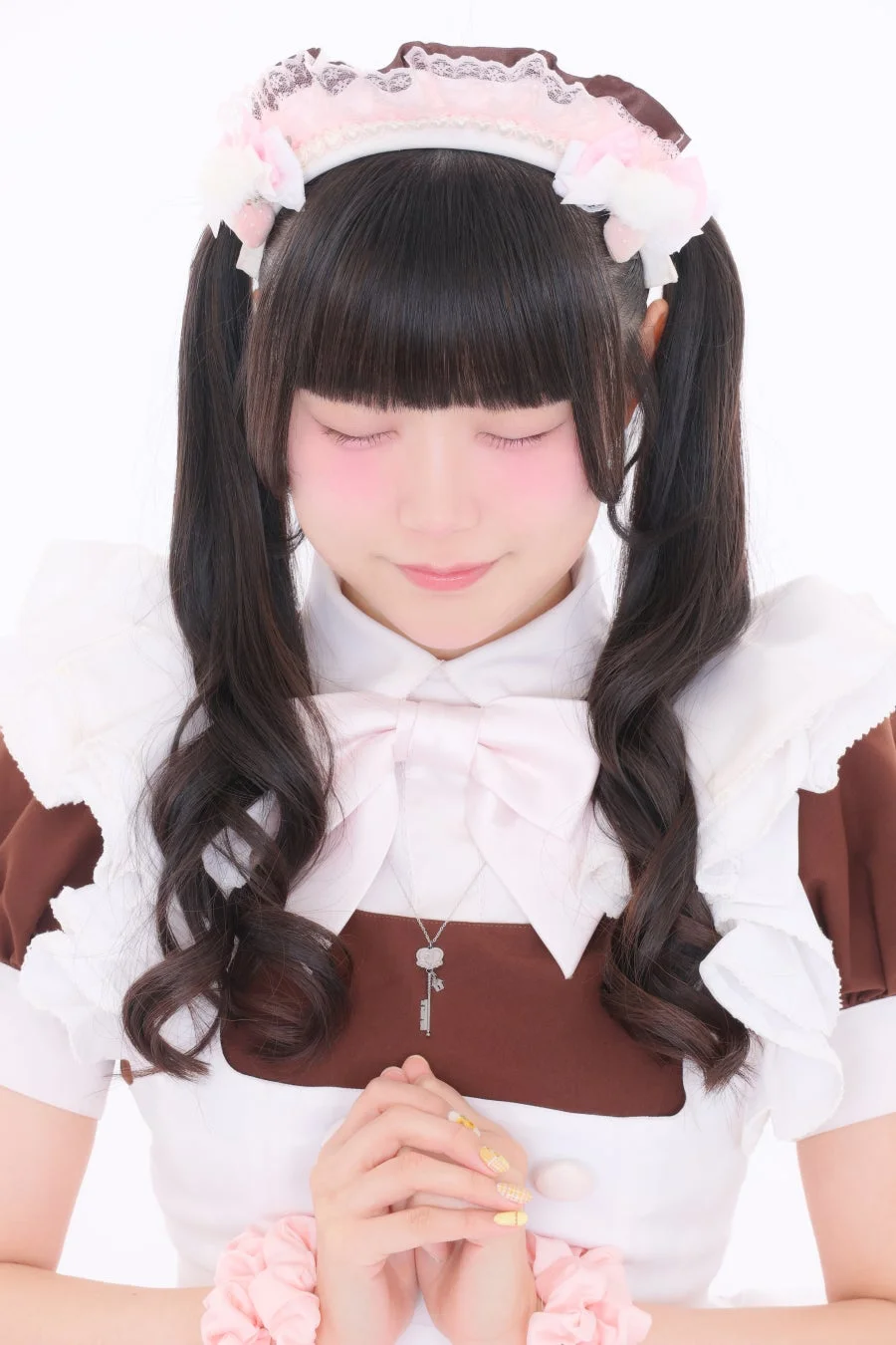 メイド服を着た女性が鍵のネックレスを着用