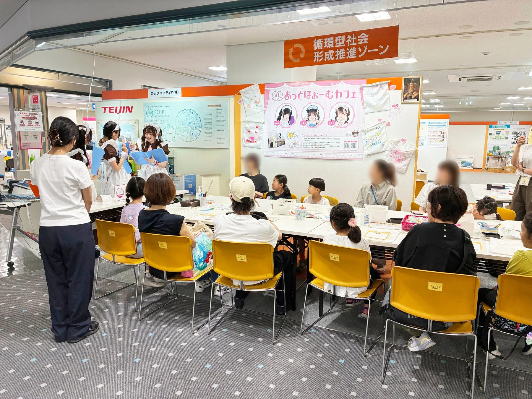 メイドさんが子どもたちにエコバッグ作りを教えている様子