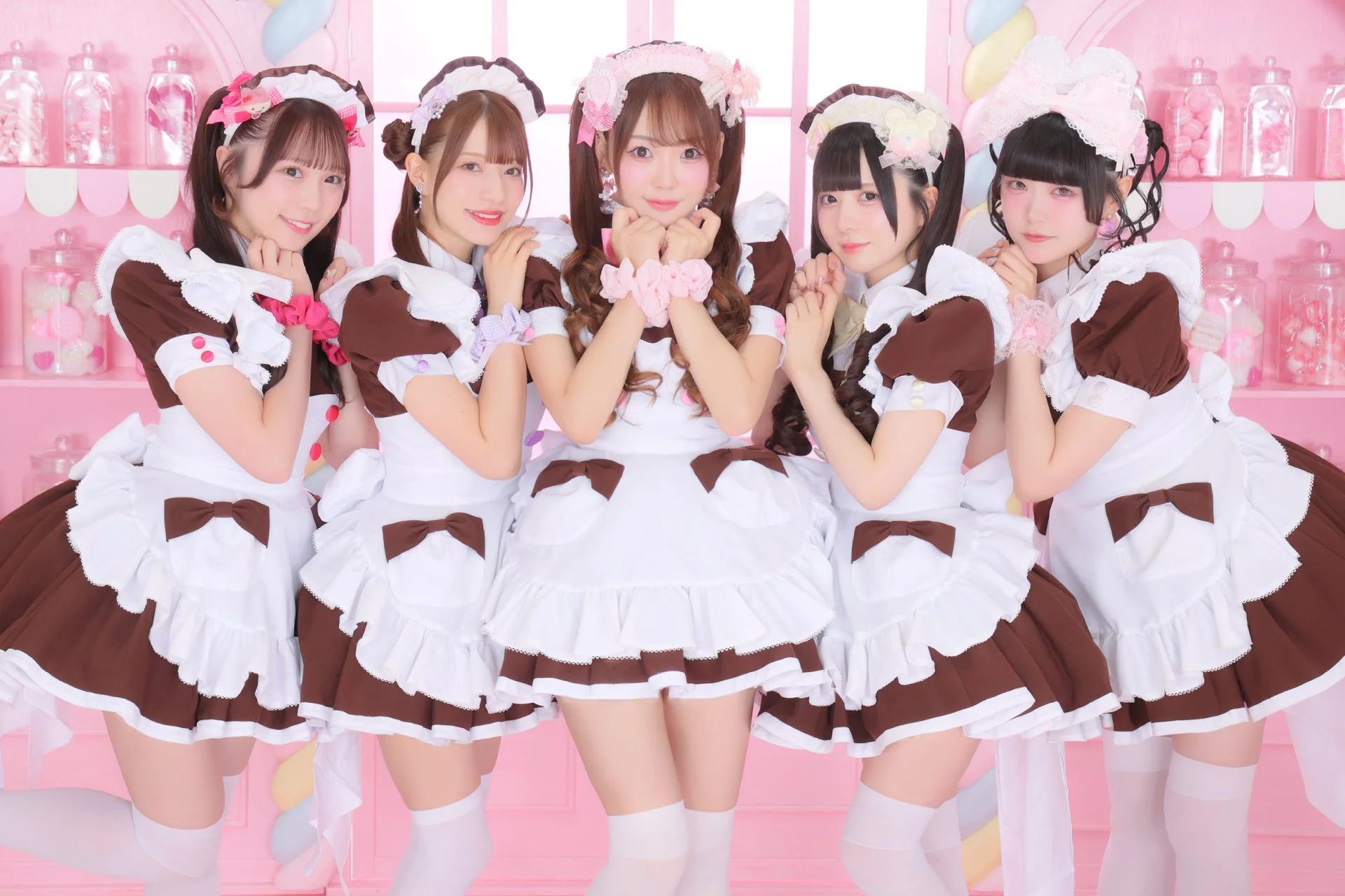 メイド服を着た5人の女性が笑顔でポーズをとっている